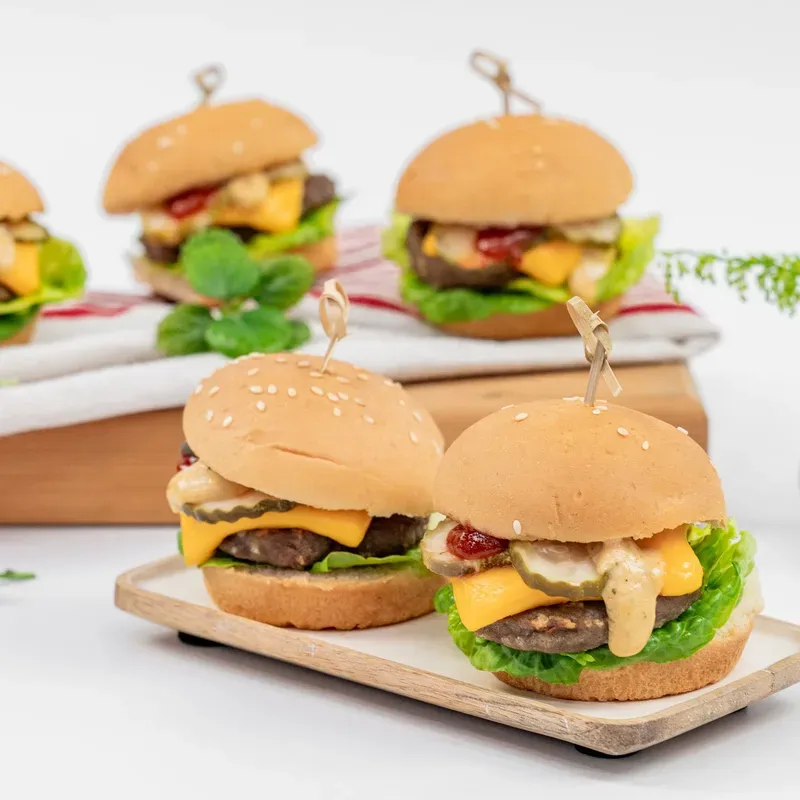 Mini cheeseburger sliders served on a wooden board