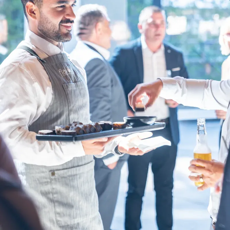 Uniformed wait staff serving guests at a funeral reception